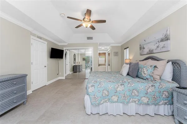a bedroom with a large bed and a chandelier