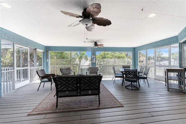 a kitchen with stainless steel appliances granite countertop wooden cabinets a refrigerator a stove a sink and a chairs