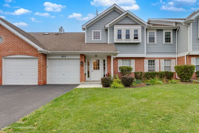 a front view of a house with a garden and yard