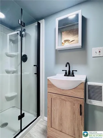 a bathroom with a sink a mirror and shower
