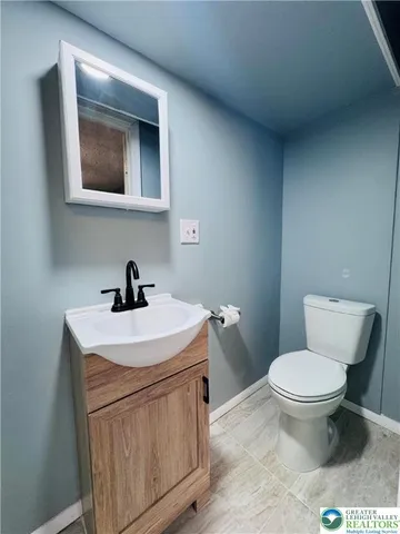 a bathroom with a toilet a sink and mirror
