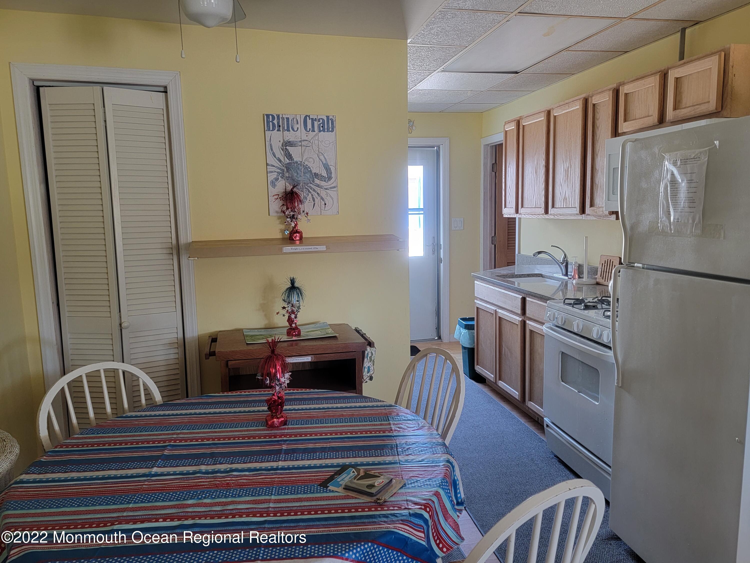 110 5th Avenue Seaside Park, NJ 08752 - Photo 10 of 25 a kitchen with a table chairs a sink and a refrigerator