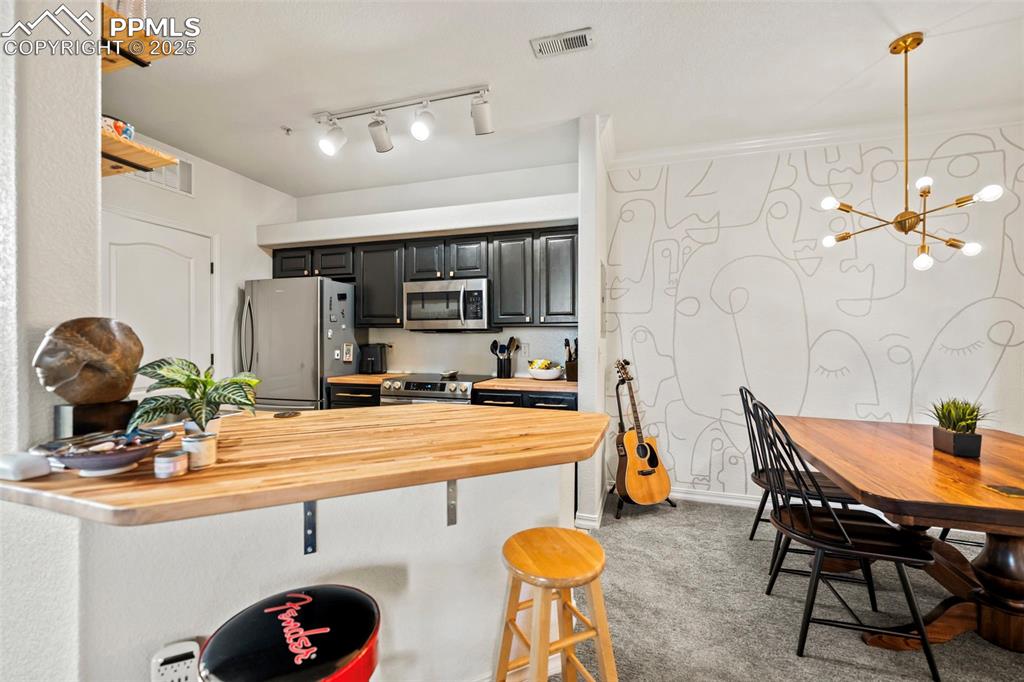 5378 Palomino Ranch Point, Unit 201 Colorado Springs, CO 80922 - Photo 4 of 15 a kitchen with stainless steel appliances kitchen island granite countertop a sink and cabinets