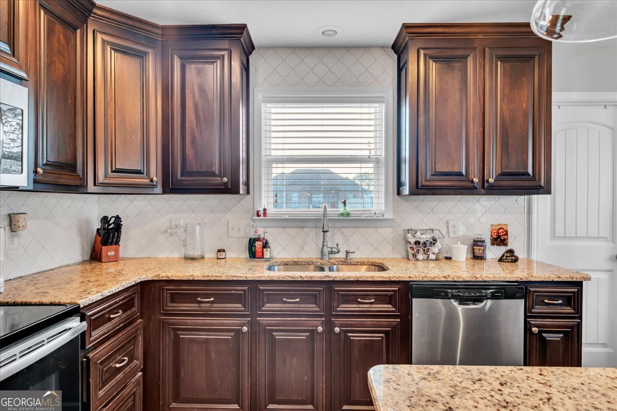 128 Gage Drive Perry, GA 31069 - Photo 11 of 38 a kitchen with stainless steel appliances granite countertop a sink stove and cabinets