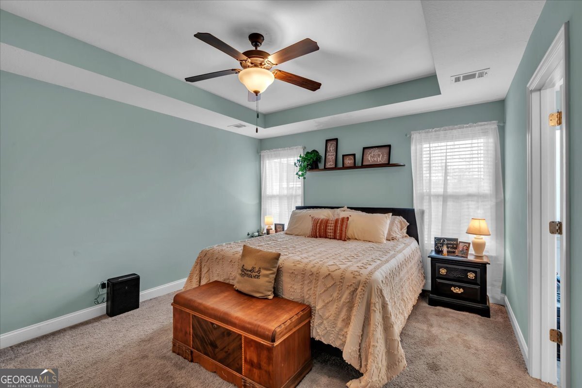 128 Gage Drive Perry, GA 31069 - Photo 15 of 38 a bedroom with a large bed and a chandelier