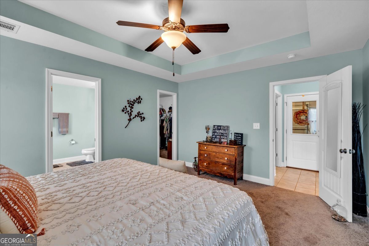 128 Gage Drive Perry, GA 31069 - Photo 16 of 38 a bedroom with a bed and a chandelier