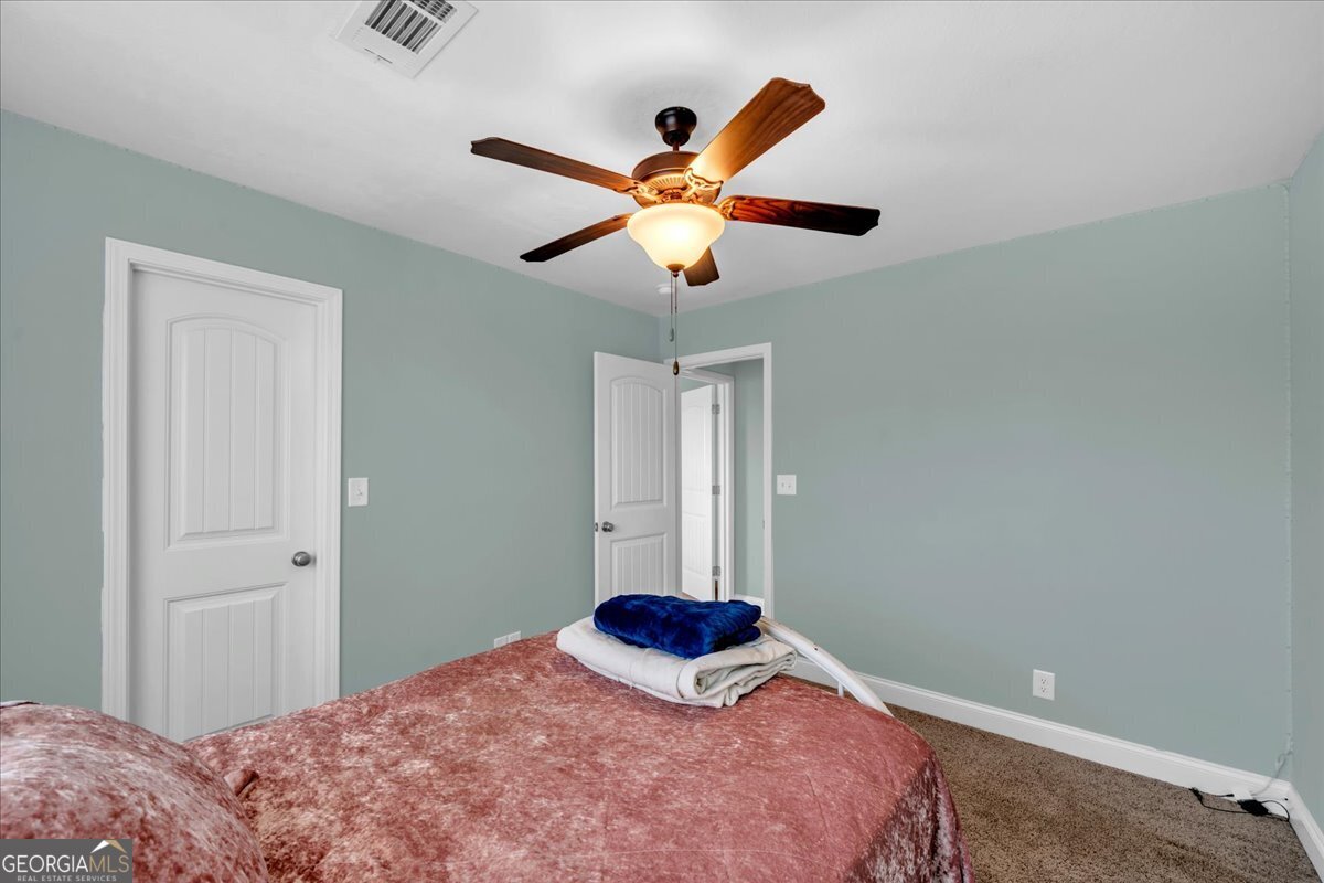 128 Gage Drive Perry, GA 31069 - Photo 22 of 38 a bedroom with a bed and a chandelier