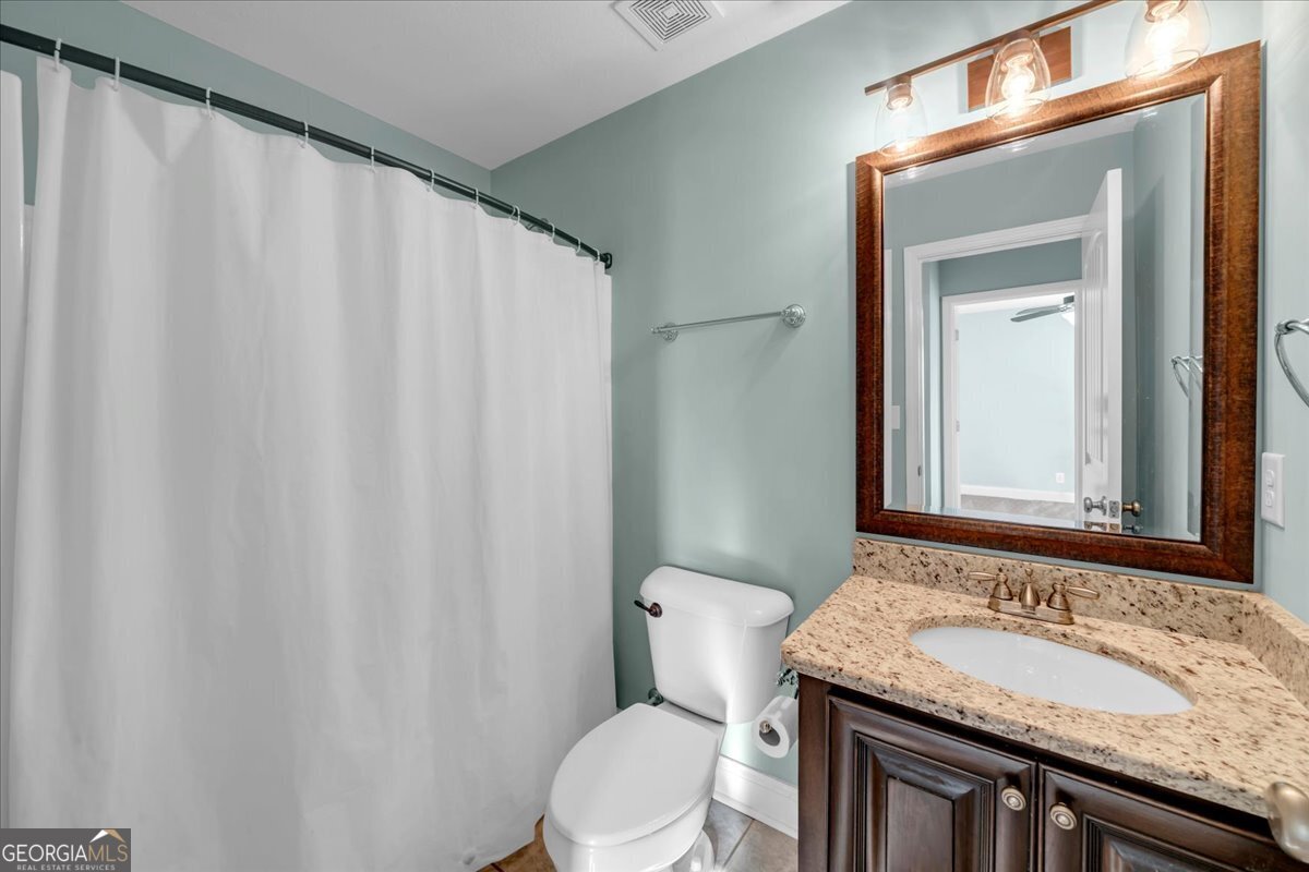 128 Gage Drive Perry, GA 31069 - Photo 25 of 38 a bathroom with a granite countertop sink and a mirror