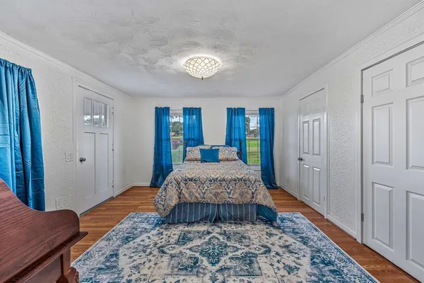 a spacious bedroom with a bed and a rug