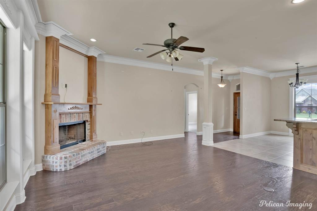 346 Wood Springs Haughton, LA 71037 - Photo 10 of 25 Unfurnished living room featuring a brick fireplace, a ceiling fan, wood finished floors, recessed lighting, and arched walkways