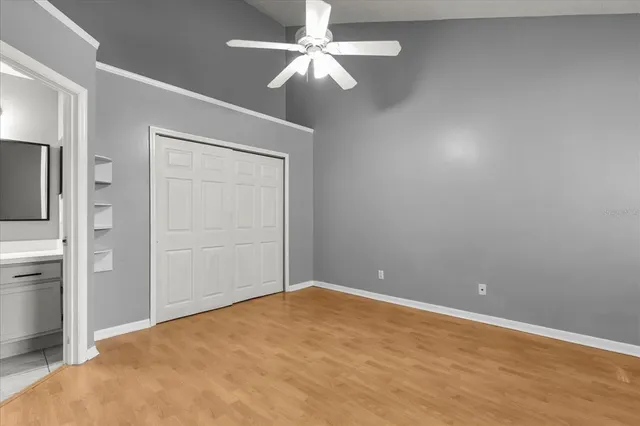 an empty room with windows and fan