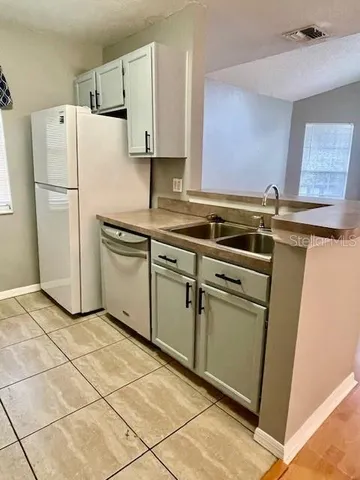 a kitchen with cabinets and white stainless steel appliances