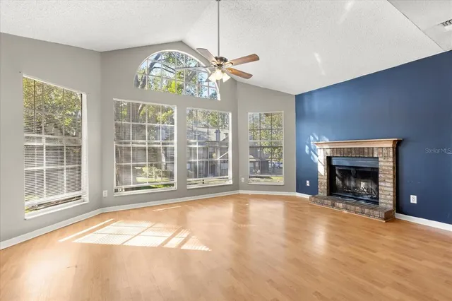 a view of an empty room with a fireplace and a window