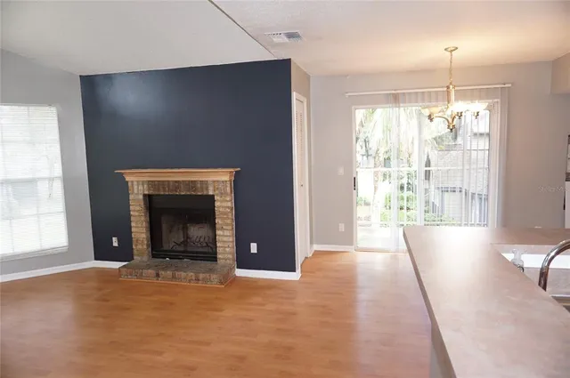 a view of an empty room with a fireplace and a window