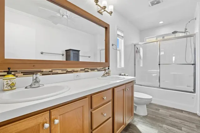 a spacious bathroom with a granite countertop sink and a mirror