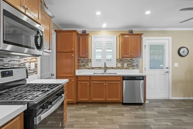 a kitchen with stainless steel appliances granite countertop a stove a sink and a refrigerator