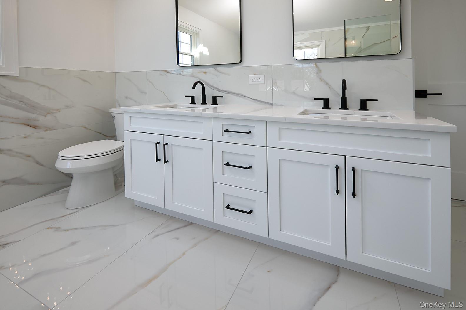 1480 Adam Place Wantagh, NY 11793 - Photo 14 of 22 Bathroom featuring double vanity, light marble finish floors, and tile walls