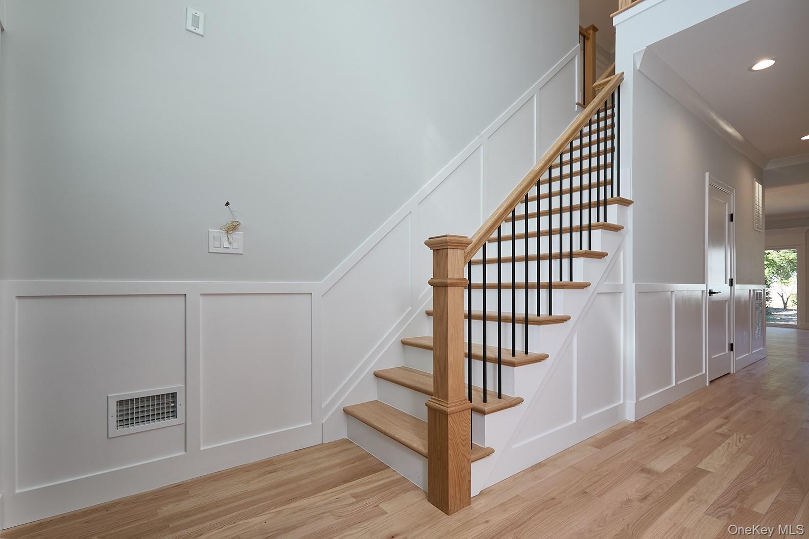 1480 Adam Place Wantagh, NY 11793 - Photo 2 of 22 Stairway featuring a decorative wall, wood finished floors, a wainscoted wall, crown molding, and recessed lighting
