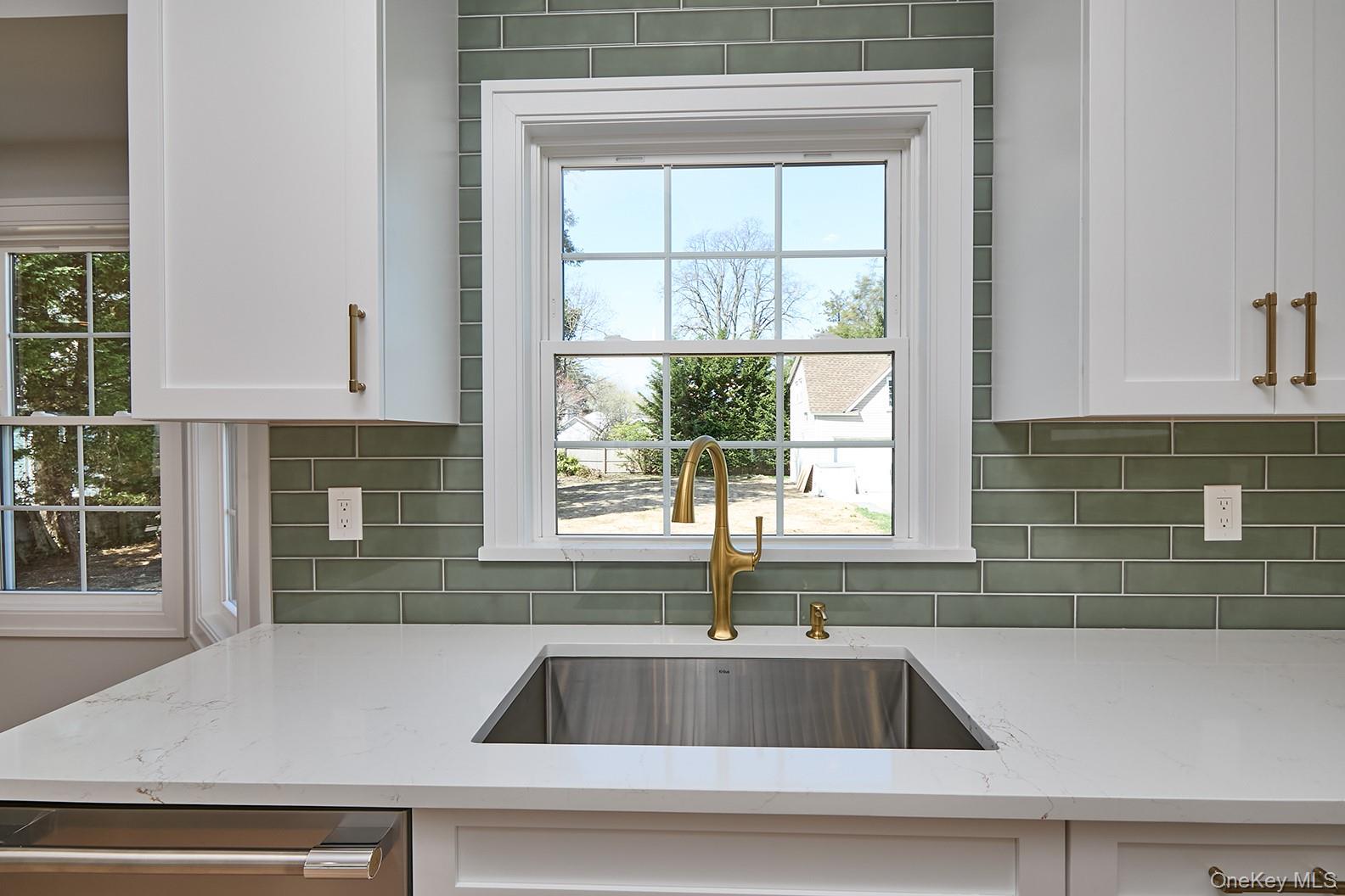 1480 Adam Place Wantagh, NY 11793 - Photo 7 of 22 Kitchen with light stone countertops, white cabinetry, and backsplash