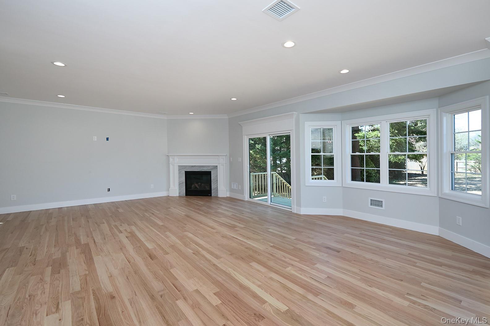 1480 Adam Place Wantagh, NY 11793 - Photo 8 of 22 Unfurnished living room featuring ornamental molding, recessed lighting, light wood-style flooring, and a premium fireplace