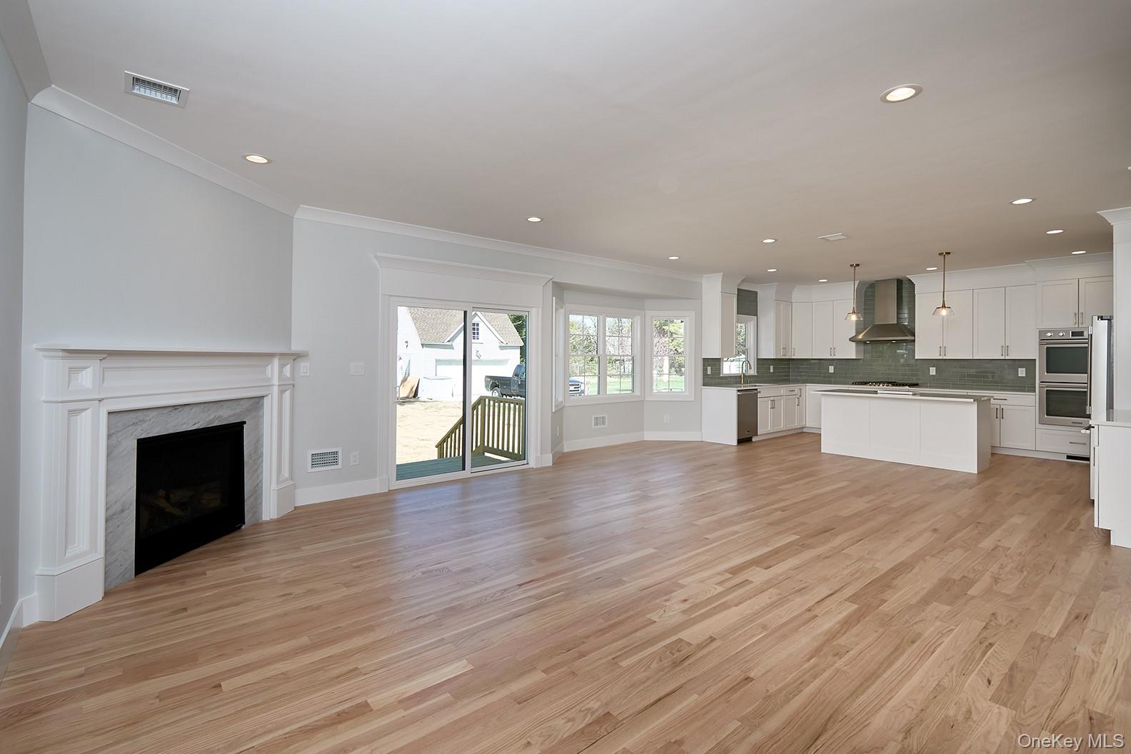 1480 Adam Place Wantagh, NY 11793 - Photo 9 of 22 Unfurnished living room featuring ornamental molding, a fireplace, light wood finished floors, and recessed lighting