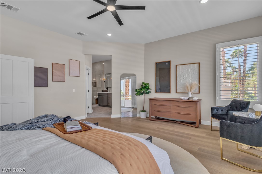 8848 Rainbow Ridge Drive Las Vegas, NV 89117 - Photo 29 of 43 Relax in this tranquil bedroom, featuring a large window, a private bathroom entrance, and wood flooring.