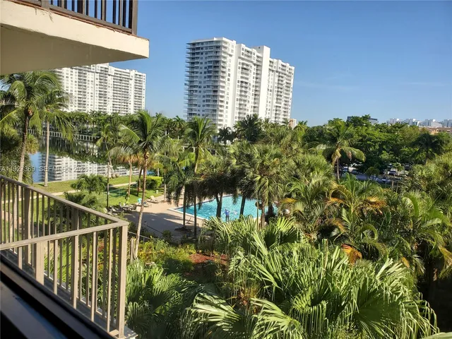 a view of a street with cars parked on the road