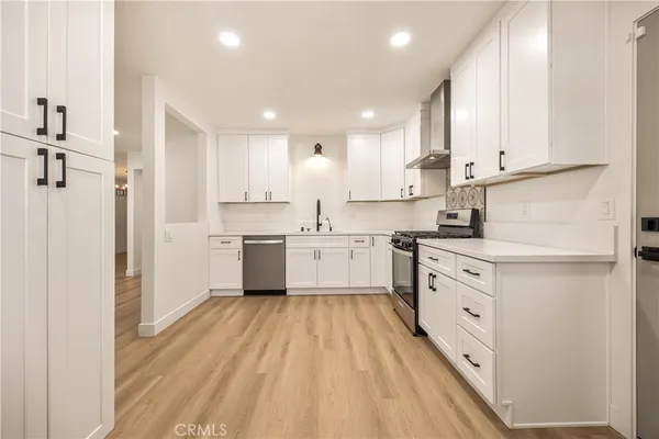 a kitchen with white cabinets stainless steel appliances and sink