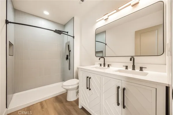 a bathroom with a double vanity sink toilet and shower