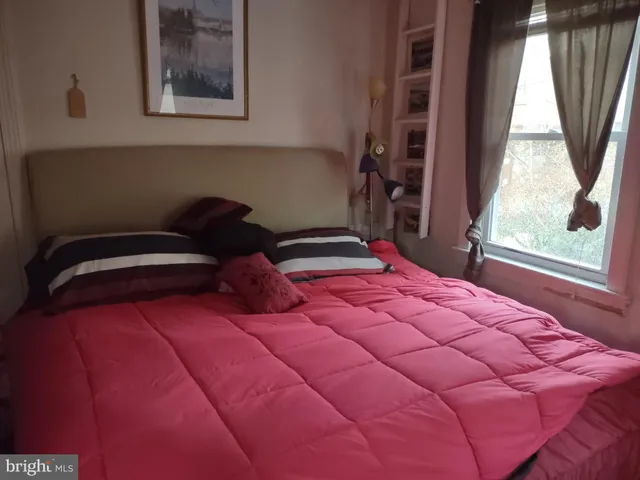 a bedroom with a bed next to a window