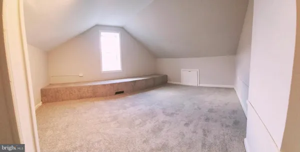 an empty room with a fireplace and windows