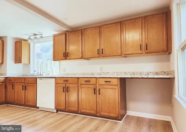 a kitchen with granite countertop wooden cabinets and a sink