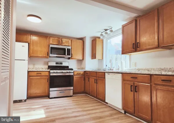 a kitchen with granite countertop a stove top oven sink and cabinets