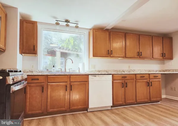 a kitchen with stainless steel appliances granite countertop wooden cabinets a sink and a granite counter tops