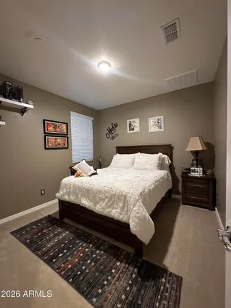 a bedroom with a bed rug and a window