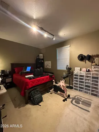 a bedroom with furniture and a air conditioner vent