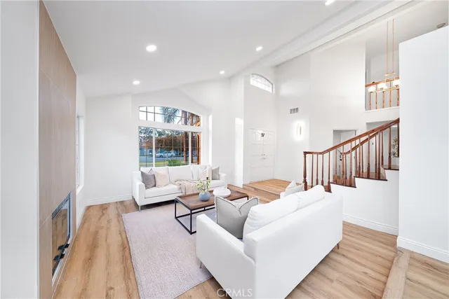 a living room with furniture wooden floor and a large window
