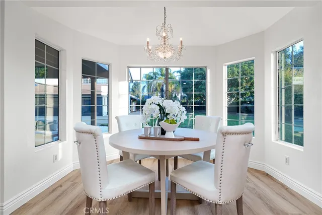 a dining room with furniture a chandelier and wooden floor