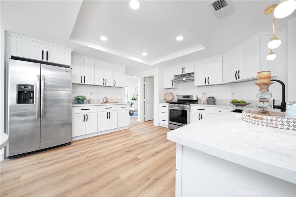 12982 Arapaho Road Rancho Cucamonga, CA 91739 - Photo 16 of 51 a kitchen with stainless steel appliances kitchen island a refrigerator sink and cabinets