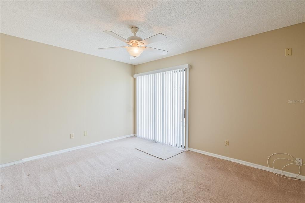 11001 Southeast Sunset Harbor Road, Unit H52 Summerfield, FL 34491 - Photo 9 of 31 an empty room with a window and a fan