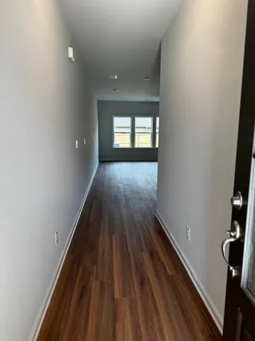 a view of a hallway with wooden floor and stairs