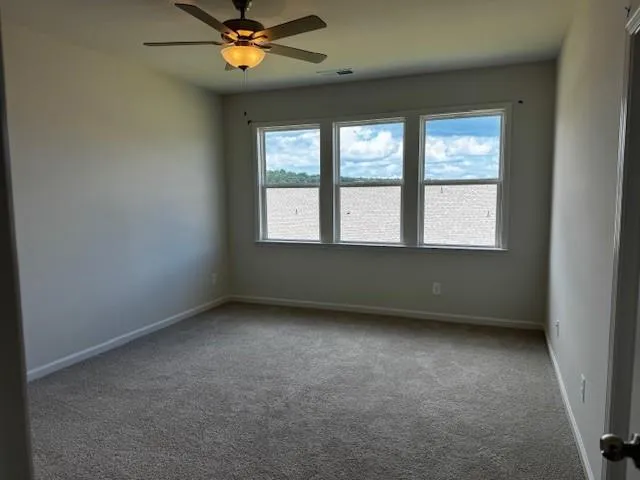 an empty room with a window and a fan