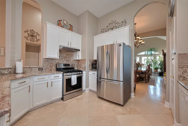 a kitchen with granite countertop a refrigerator and a sink