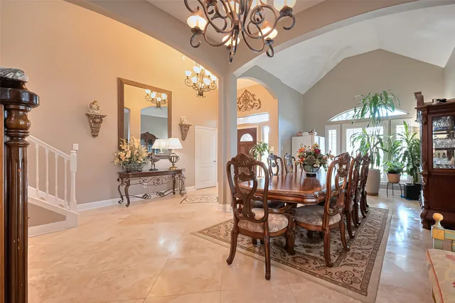 a view of a dining room with furniture a chandelier and wooden floor