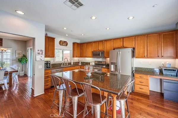 a kitchen with stainless steel appliances granite countertop a stove top oven and cabinets