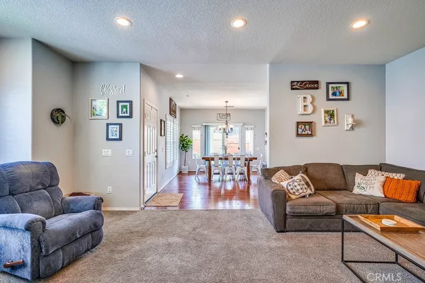 a living room with furniture a chandelier and a large window