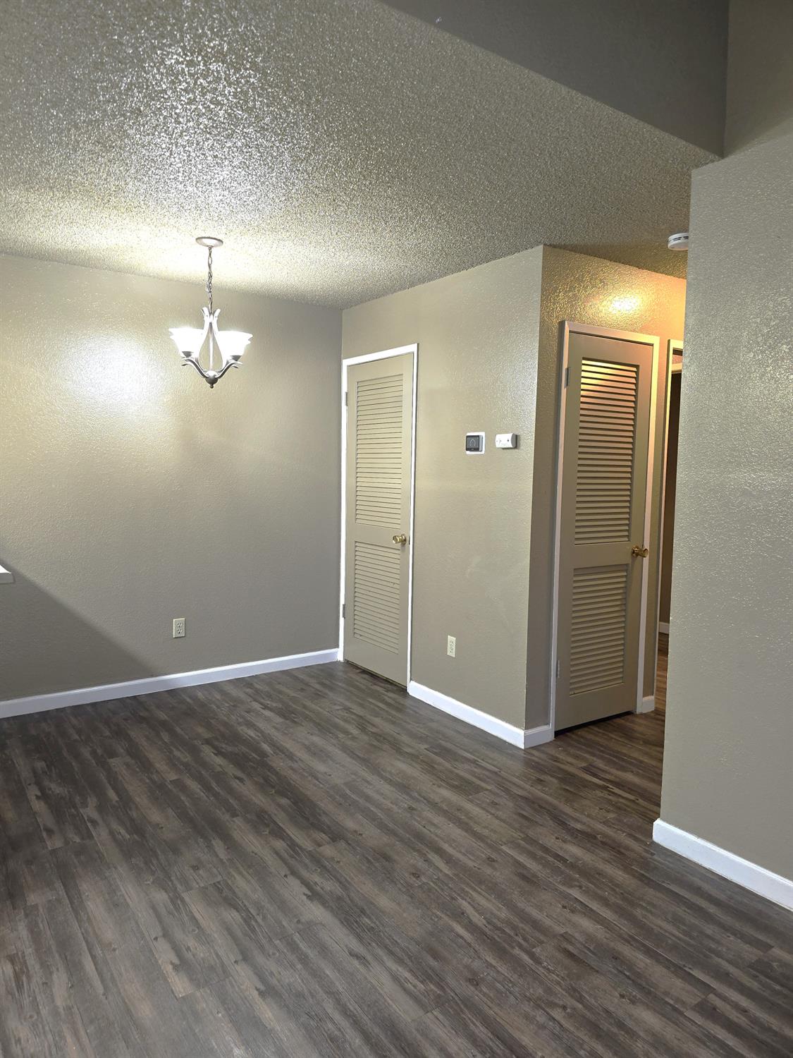 3939 Madison Avenue, Unit 220 North Highlands, CA 95660 - Photo 4 of 12 an empty room with wooden floor and mirror