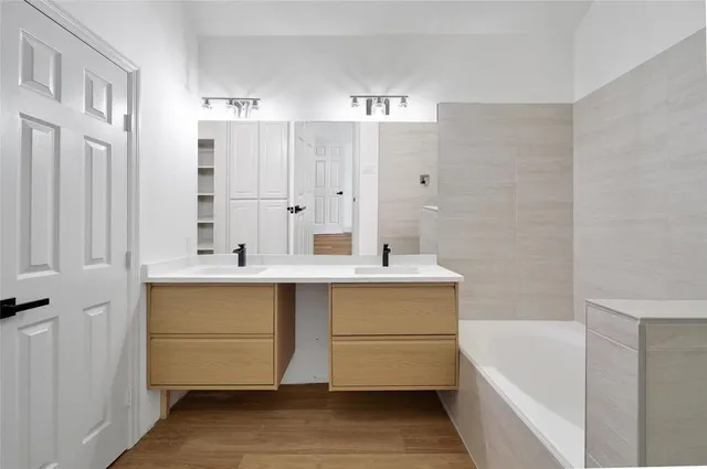 a bathroom with a tub sink and mirror