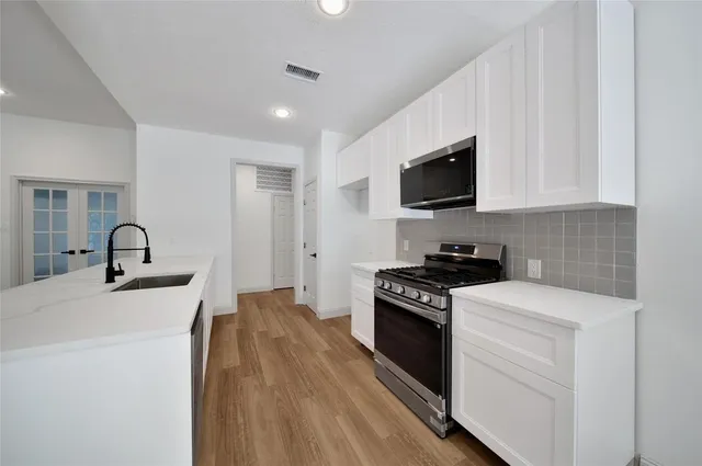 a kitchen with stainless steel appliances granite countertop a stove a sink and a refrigerator