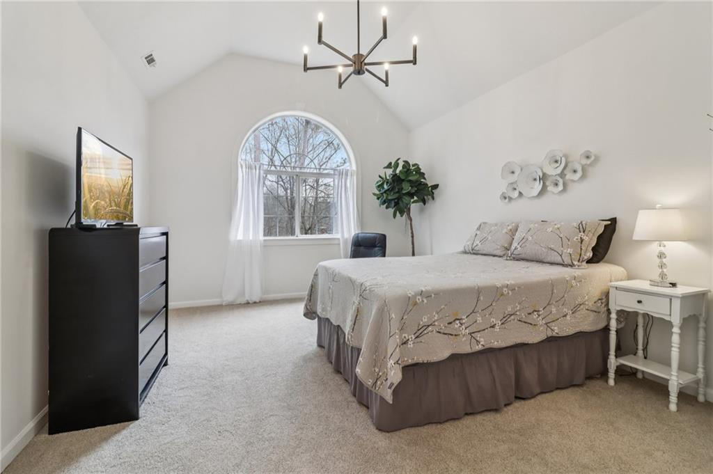 175 Meredith Way Stockbridge, GA 30281 - Photo 30 of 75 a spacious bedroom with a bed and a chandelier
